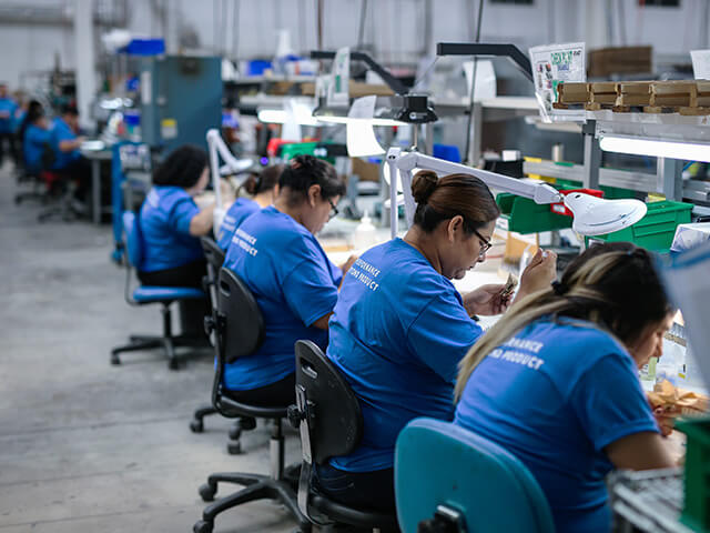 Women in blue shirts working in production line
