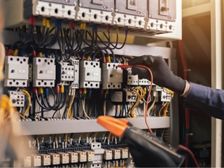 Electrician adjusting settings of circuit box