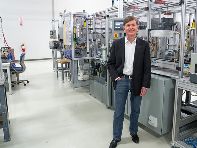 CEO Kieran O'Sullivan smiling with hand in pocket, standing in manufacturing area