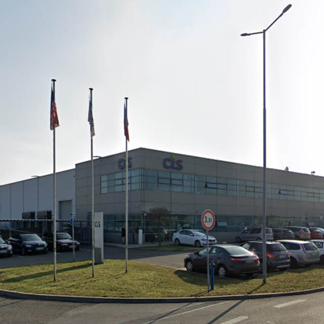 CTS facility with cars parked in parking lot with flag polls on parkway, located in Ostrava, Czech Republic