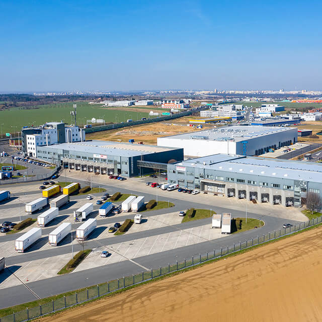 CTS facility with large parking lot housing semitruck trailers and cars with blue sky, located in Prague, Czech Republic