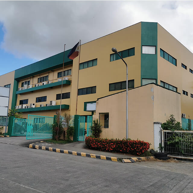 CTS green and tan facility on front drive way with flag pole on parkway located in Philippines