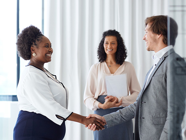 Smiling Business Woman shaking business mans hand
