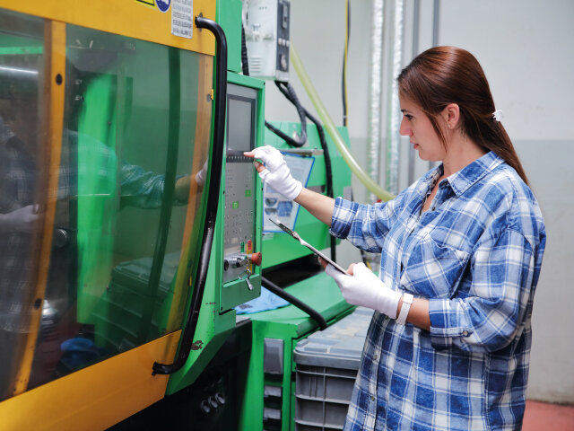 Person operating equipment and pressing a switch on a panel