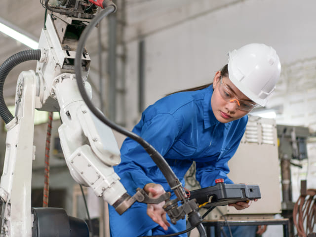 Engineer inspecting robotic arm