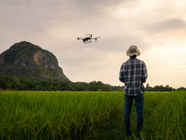 Man in field piloting a drone
