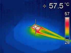 Image showing a small sample, hard-doped ceramic 3*3*2mm, 200V, lying on a ceramic plate in ambient conditions, operated at 2kHz, full amplitude heating-up by +30°C