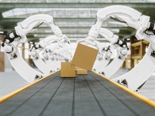Robotic arms handling packages on assembly line