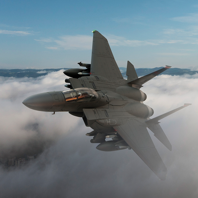 Image of jet grey flying through clouds