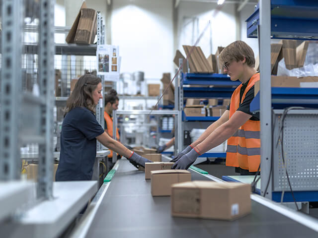 Man and woman team smiling while leaning on distribution line