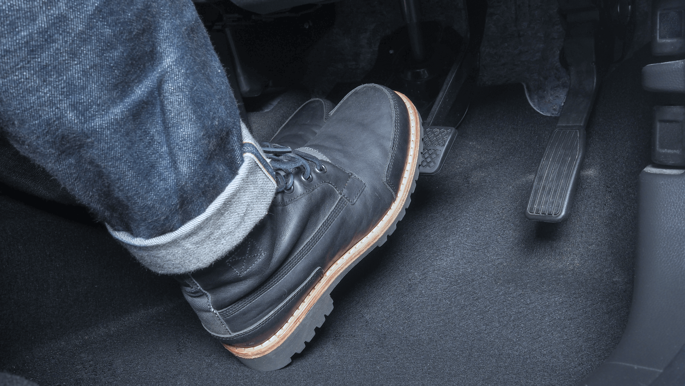 Foot pressing on brake pedal in car