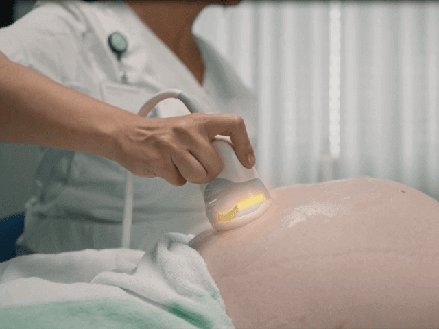 medical room with pregnant patient receiving ultrasound exam