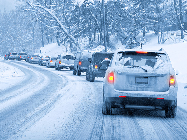 Snow covered cars braking on snowy road