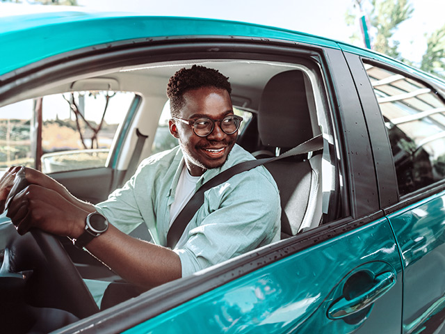 Man leaning in car driver seat with seatbelt on