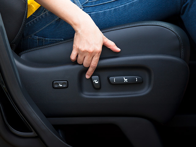 Woman pressing on seat adjustment controls