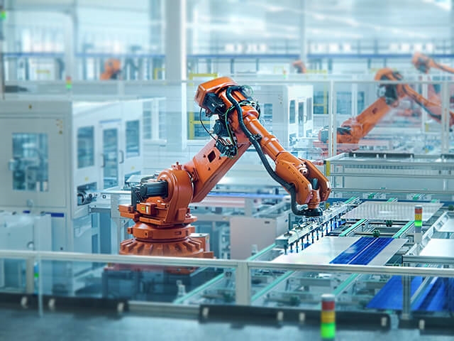Orange robot arm in manufacturing facility